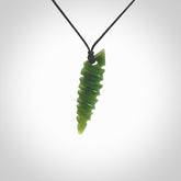 This photo shows a contemporary drop carved into New Zealand Jade. The artist, Shaun Gardiner, has carved this beautifully. We have added an adjustable black cord. This is a fantastic work of art, we have one only.